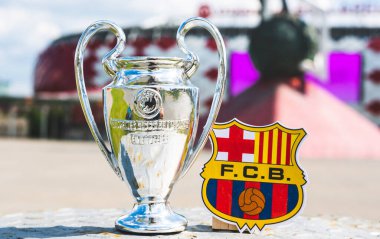 14 Haziran 2021 Barselona, İspanya. FC Barcelona amblemi ve UEFA Şampiyonlar Ligi Kupası modern bir stadyumun arka planına karşıdır..