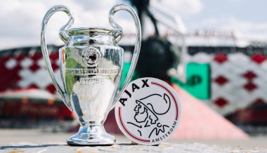 14 Haziran 2021 Amsterdam, Hollanda. AFC Ajax futbol kulübü ve UEFA Şampiyonlar Ligi Kupası 'nın amblemi modern bir stadyumun arka planına karşıdır..