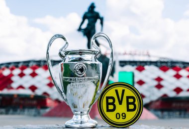 14 Haziran 2021 Dortmund, Almanya. Borussia Dortmund futbol kulübü ve UEFA Şampiyonlar Ligi Kupası 'nın amblemi modern bir stadyumun arka planına karşıdır..