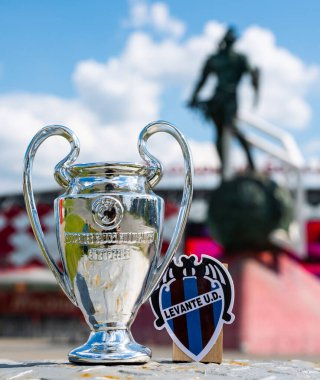 14 Haziran 2021, Valencia, İspanya. Levante UD futbol kulübü ve UEFA Şampiyonlar Ligi Kupası 'nın amblemi modern bir stadyumun arka planına karşıdır..