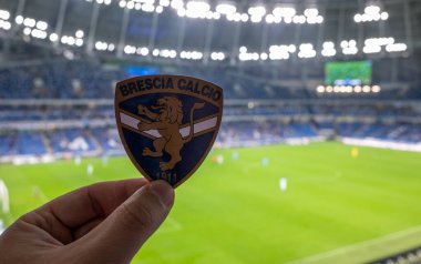 12 Eylül 2021, Brescia, İtalya. Futbol kulübü Brescia Calcio 'nun amblemi modern bir stadyumun arka planına karşı..