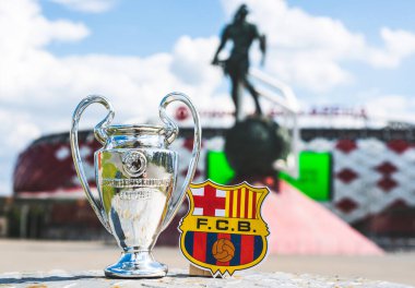 14 Haziran 2021 Barselona, İspanya. FC Barcelona amblemi ve UEFA Şampiyonlar Ligi Kupası modern bir stadyumun arka planına karşıdır..