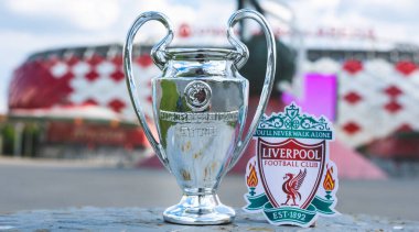 14 Haziran 2021 Liverpool, İngiltere. Liverpool F.C. Futbol kulübü amblemi ve UEFA Şampiyonlar Ligi Kupası modern bir stadyumun arka planına karşı..