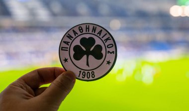 12 Eylül 2021 Atina, Yunanistan. Modern bir stadyumun arka planında Panathinaikos F. C. ve UEFA Şampiyonlar Ligi Kupası 'nın amblemi yer almaktadır..