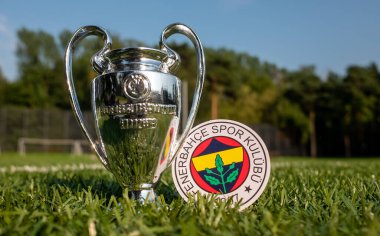 30 Ağustos 2021, İstanbul, Türkiye. Fenerbahçe S.K. futbol kulübünün amblemi. Ve yeşil bir alanda UEFA Şampiyonlar Ligi Kupası..