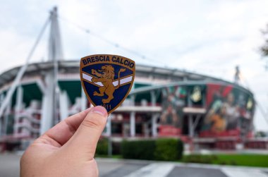 30 Ağustos 2021, Brescia, İtalya. Futbol kulübü Brescia Calcio 'nun amblemi modern bir stadyumun arka planına karşı..