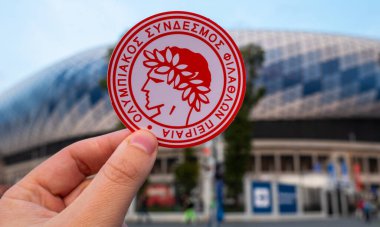 13 Eylül 2021 Atina, Yunanistan. Futbol kulübü Olympiacos Pire 'nin amblemi modern stadyumun arka planına karşıdır..