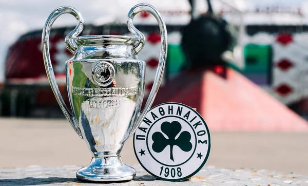 14 Haziran 2021 Atina, Yunanistan. Modern bir stadyumun arka planında Panathinaikos F. C. ve UEFA Şampiyonlar Ligi Kupası 'nın amblemi yer almaktadır..