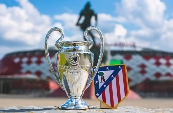 14 Haziran 2021 Madrid, İspanya. Atletico Madrid futbol kulübü ve UEFA Şampiyonlar Ligi Kupası 'nın amblemi modern bir stadyumun arka planına karşıdır..