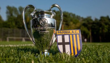 30 Ağustos 2021, Parma. Parma Calcio futbol kulübü amblemi ve stadyumun yeşil sahasında UEFA Şampiyonlar Ligi Kupası.