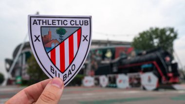 30 Ağustos 2021 Bilbao, İspanya. Futbol kulübü Athletic Bilbao 'nun amblemi modern stadyumun arka planına karşıdır..