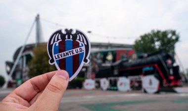 30 Ağustos 2021, Valencia, İspanya. Futbol kulübü Levante UD 'nin amblemi modern bir stadyumun arka planına karşıdır..
