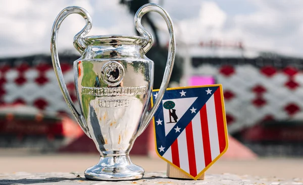 14 Haziran 2021 Madrid, İspanya. Atletico Madrid futbol kulübü ve UEFA Şampiyonlar Ligi Kupası 'nın amblemi modern bir stadyumun arka planına karşıdır..