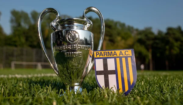 30 Ağustos 2021, Parma. Parma Calcio futbol kulübü amblemi ve stadyumun yeşil sahasında UEFA Şampiyonlar Ligi Kupası.