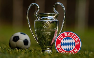 27 Ağustos 2021, Münih, Almanya. FC Bayern Münih futbol amblemi ve UEFA Şampiyonlar Ligi Kupası stadyumun yeşil sahasında.