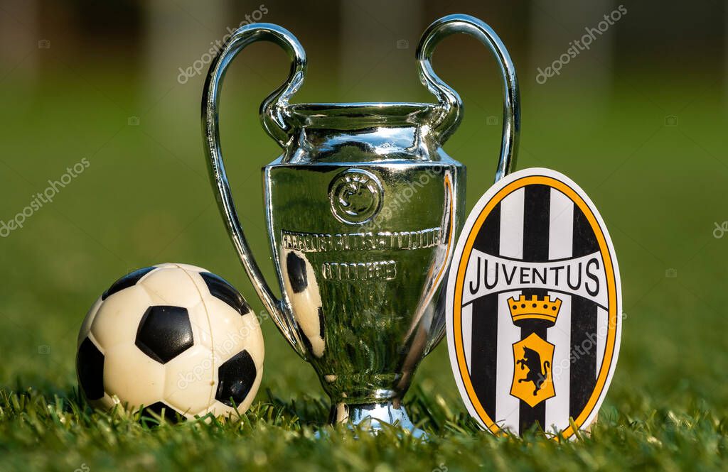August 27, 2021, Turin, Italy. The Juventus football club emblem and the UEFA Champions League Cup on the green turf of the stadium.