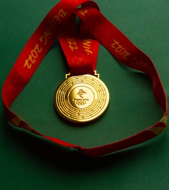 6 Ocak 2021, Pekin Çin. Yeşil zemin üzerinde 14. Olimpiyat Kış Oyunları 'nın altın madalyası.