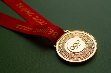 6 Ocak 2021, Pekin Çin. Yeşil zemin üzerinde 14. Olimpiyat Kış Oyunları 'nın altın madalyası.