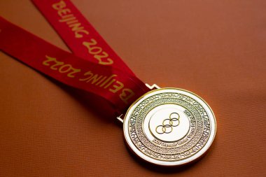 6 Ocak 2021, Pekin Çin. Turuncu arka planda 14. Olimpiyat Kış Oyunları 'nın altın madalyası.