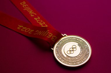 6 Ocak 2021, Pekin Çin. Kırmızı zemin üzerinde 14. Olimpiyat Kış Oyunları 'nın altın madalyası.