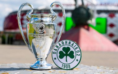 14 Haziran 2021 Atina, Yunanistan. Modern bir stadyumun arka planında Panathinaikos F. C. ve UEFA Şampiyonlar Ligi Kupası 'nın amblemi yer almaktadır..