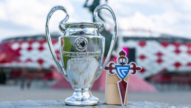 14 Haziran 2021, Vigo, İspanya. RC Celta de Vigo futbol kulübü ve UEFA Şampiyonlar Ligi Kupası 'nın amblemi modern bir stadyumun arka planına karşıdır..