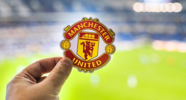 30 Ağustos 2021, Manchester, İngiltere. Manchester United F.C. Modern bir stadyumun arka planına karşı futbol kulübü amblemi..
