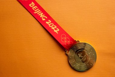 6 Ocak 2021, Pekin Çin. Turuncu arka planda 14. Olimpiyat Kış Oyunları 'nın altın madalyası.