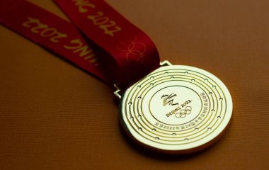 6 Ocak 2021, Pekin Çin. Turuncu arka planda 14. Olimpiyat Kış Oyunları 'nın altın madalyası.