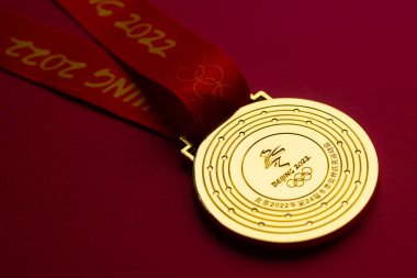 6 Ocak 2021, Pekin Çin. Kırmızı zemin üzerinde 14. Olimpiyat Kış Oyunları 'nın altın madalyası.