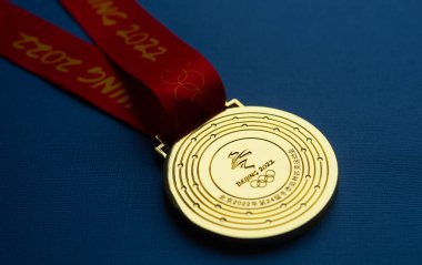 6 Ocak 2021, Pekin Çin. Mavi arka planda 14. Olimpiyat Kış Oyunları 'nın altın madalyası.