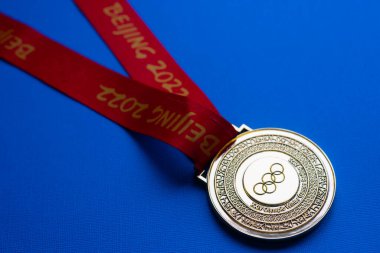 6 Ocak 2021, Pekin Çin. Mavi arka planda 14. Olimpiyat Kış Oyunları 'nın altın madalyası.