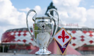 14 Haziran 2021, Floransa, İtalya. ACF Fiorentina futbol kulübü ve UEFA Şampiyonlar Ligi Kupası 'nın amblemi modern bir stadyumun arka planına karşıdır..