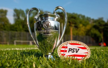 30 Ağustos 2021, Eindhoven, Hollanda. PSV Eindhoven futbol kulübü amblemi ve stadyumun yeşil sahasında UEFA Şampiyonlar Ligi Kupası.
