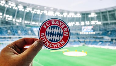 12 Eylül 2021, Münih, Almanya. Futbol kulübü FC Bayern Münih 'in amblemi modern bir stadyumun arka planında.