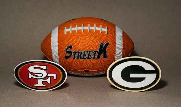 stock image January 18, 2022. Green Bay, Wisconsin. The emblems of the football clubs of the playoffs of the National Football League season 2021/2022 San Francisco 49ers and Green Bay Packers on a blue background.