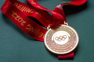 14 Ocak 2022, Pekin, Çin. Yeşil zemin üzerinde 14. Olimpiyat Kış Oyunları 'nın altın madalyası.