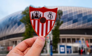 12 Eylül 2021, Sevilla, İspanya. Futbol kulübü Sevilla FC 'nin amblemi modern bir stadyumun arka planına karşıdır..