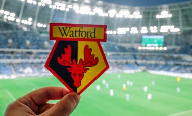 12 Eylül 2021, Moskova, Rusya. Watford Futbol Kulübü 'nün amblemi modern bir stadyumun arka planına karşı..