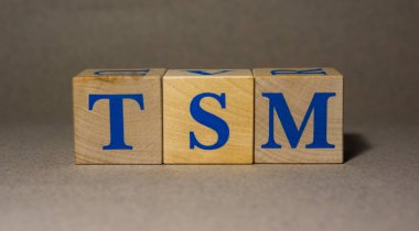 19 Ocak 2022. New York, ABD. Tayvan Yarı iletken Üretim Şirketi 'nin hisse senedi Ticker sembolü Gri arka planda tahta küplerden yapılmış TSM..