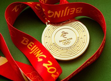 27 Ocak 2022, Pekin, Çin. Yeşil arka planda 14. Olimpiyat Kış Oyunları altın madalyası.