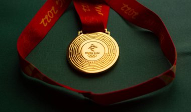 6 Ocak 2021, Pekin Çin. Yeşil zemin üzerinde 14. Olimpiyat Kış Oyunları 'nın altın madalyası.