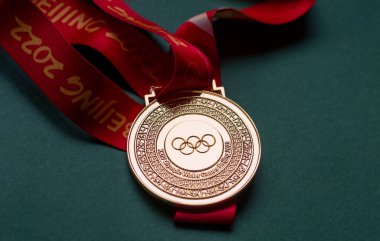 14 Ocak 2022, Pekin, Çin. Yeşil zemin üzerinde 14. Olimpiyat Kış Oyunları 'nın altın madalyası.