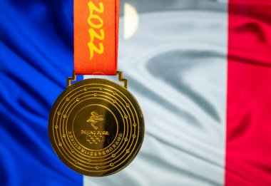 5 Ocak 2021, Pekin Çin. 14. Olimpiyat Kış Oyunları 'nın altın madalyası Fransa bayrağının arka planına karşı.