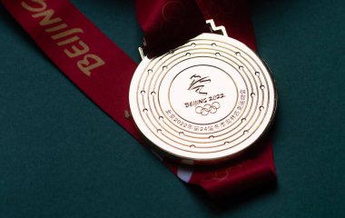14 Ocak 2022, Pekin, Çin. Yeşil zemin üzerinde 14. Olimpiyat Kış Oyunları 'nın altın madalyası.