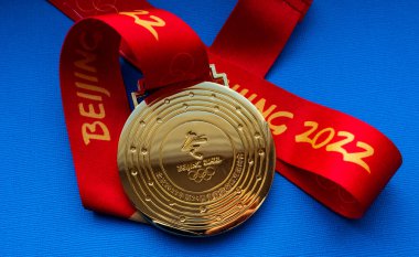 27 Ocak 2022, Pekin, Çin. Mavi arka planda 14. Olimpiyat Kış Oyunları altın madalyası.