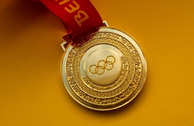 27 Ocak 2022, Pekin, Çin. 14. Olimpiyat Kış Oyunları altın madalyası sarı arka planda.