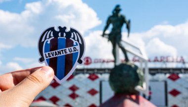 14 Haziran 2021, Valencia, İspanya. Futbol kulübü Levante UD 'nin amblemi modern bir stadyumun arka planına karşıdır..