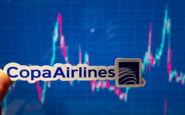 10 Kasım 2021, Panama. Copa Havayolları 'nın amblemi bir hisse senedi fiyat tablosunun arka planına karşı.