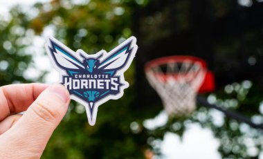 15 Eylül 2021, Charlotte, ABD Charlotte Hornets basketbol kulübünün logosu elinde..